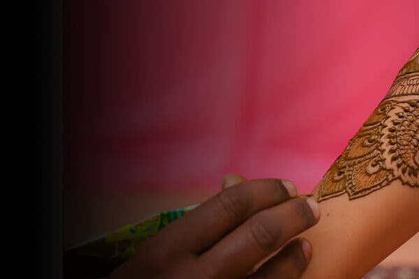A beautician is giving mehendi design